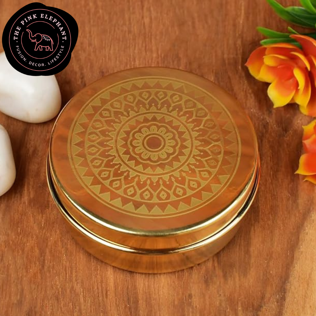 Decorative gold lid with intricate patterns on a wooden surface