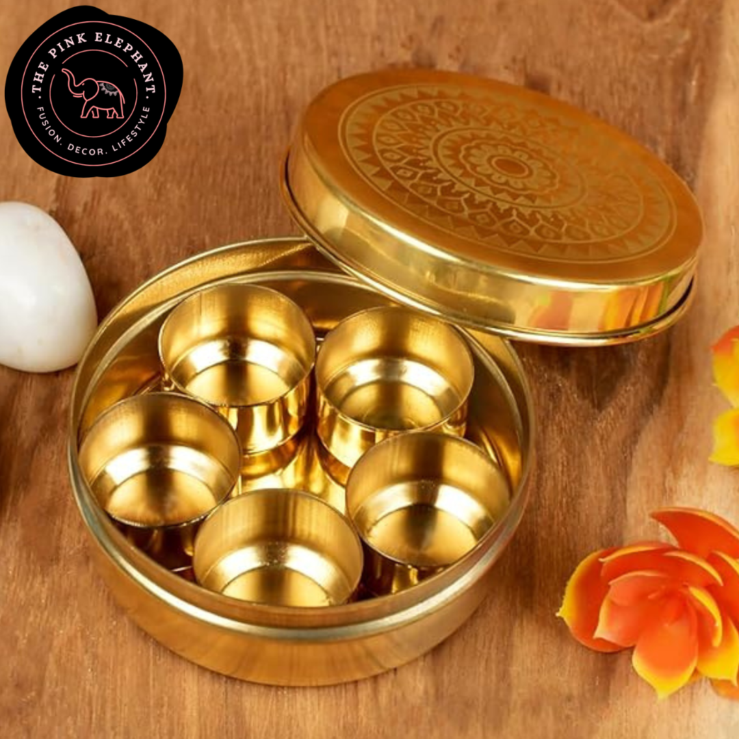 Gold decorative items in a round container on a wooden surface to store spices